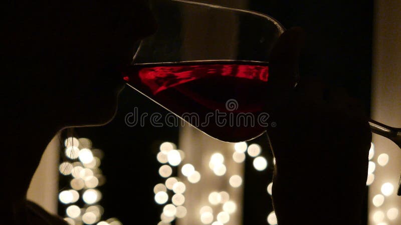 喝在圣诞节的美丽的少妇红葡萄酒