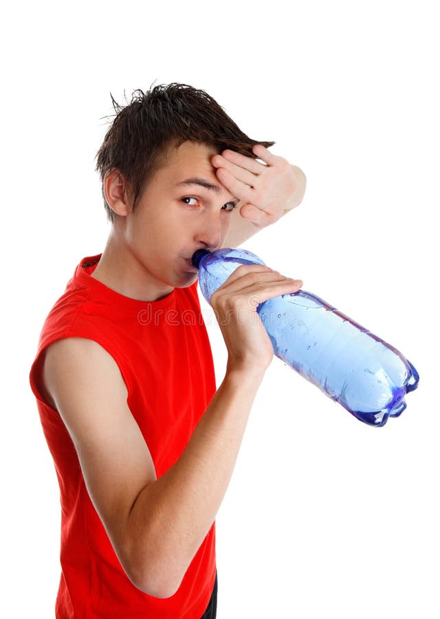 Teen boy wiping his brow and drinking water from a bottle. Teen boy wiping his brow and drinking water from a bottle.