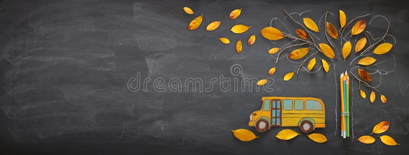 回到概念学校 顶视图横幅校车和铅笔在树剪影旁边与秋天烘干叶子在blackboar的教室 免版税库存图片
