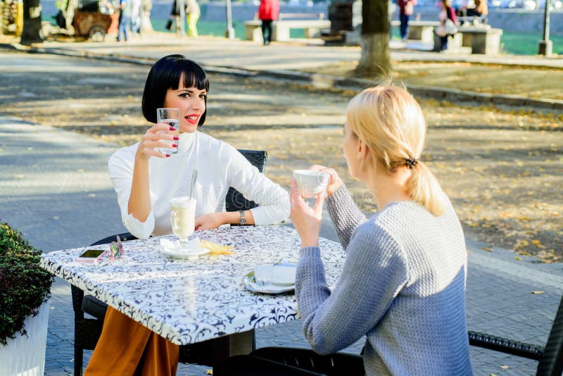 Togetherness female friendship. Trustful communication. Girls friends drink coffee and enjoy talk. True friendship friendly close relations. Conversation of two women cafe terrace. Friendship meeting. Togetherness female friendship. Trustful communication. Girls friends drink coffee and enjoy talk. True friendship friendly close relations. Conversation of two women cafe terrace. Friendship meeting.