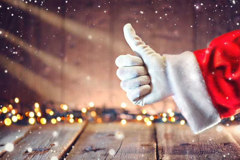 Santa Claus thumb up gesture over Christmas holiday wooden background. Santa Claus thumb up gesture over Christmas holiday wooden background