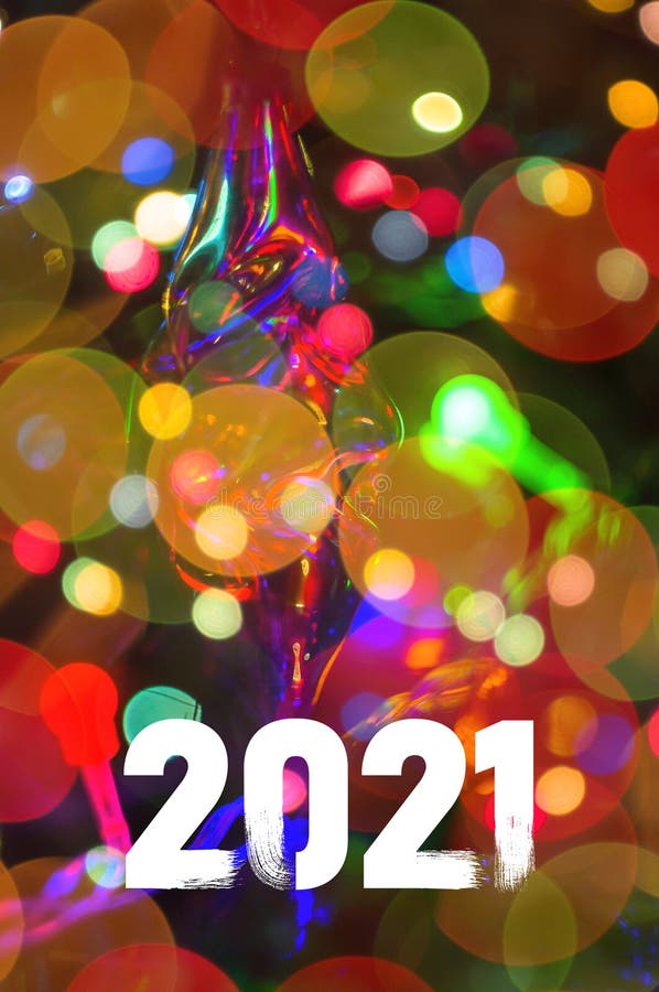圣诞背景花园，装饰着彩灯的圣诞树，带着2021年彩色的新年快乐 免版税库存图片