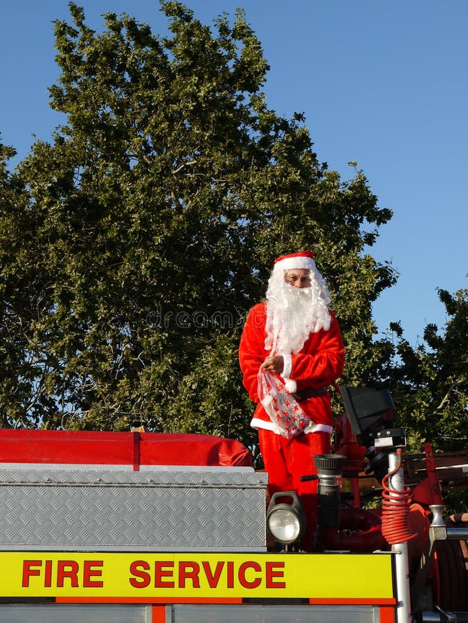 Christmas parade santa about to throw lollies (candy) to kids from top of fire truck in Northland, New Zealand. Christmas parade santa about to throw lollies (candy) to kids from top of fire truck in Northland, New Zealand