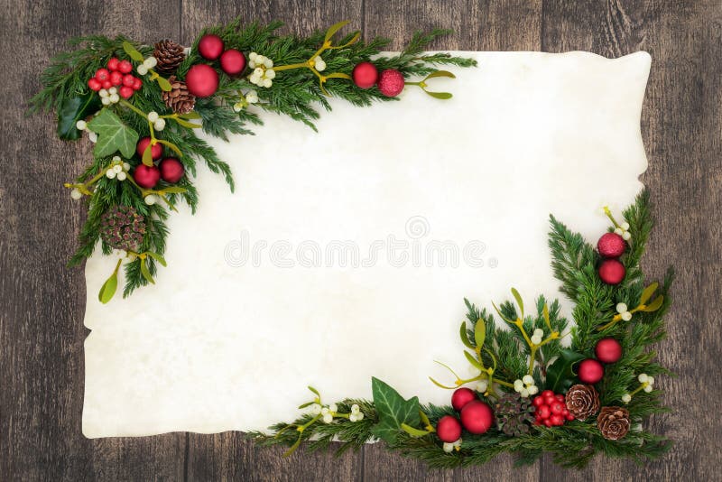 Christmas background border on parchment paper on oak wood with red bauble decorations, holly, mistletoe, ivy, fir and pine cones. Christmas background border on parchment paper on oak wood with red bauble decorations, holly, mistletoe, ivy, fir and pine cones.