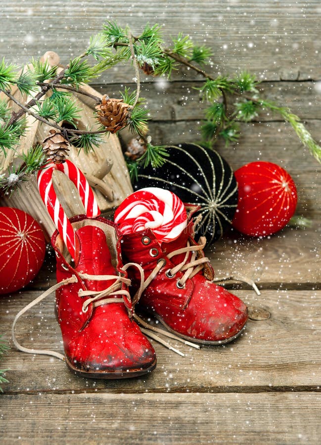 Christmas stocking. nostalgic decoration with antique toys and vintage baby shoes over wooden background. retro style picture with falling snowflakes effect. Christmas stocking. nostalgic decoration with antique toys and vintage baby shoes over wooden background. retro style picture with falling snowflakes effect