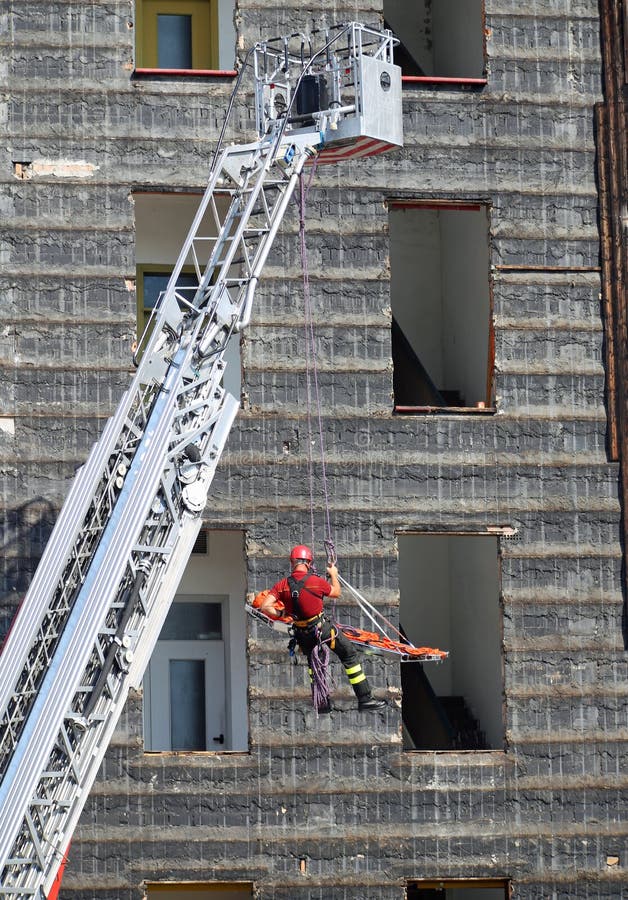 Fearless fireman during an exercise carries the stretcher with the climbing rope. Fearless fireman during an exercise carries the stretcher with the climbing rope