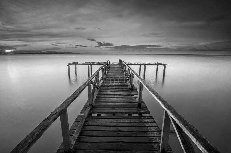 Calm scene in black and white with abandoned jetty at Teluk Tempoyak, Penang, Malaysia. black and white (fine art). Calm scene in black and white with abandoned jetty at Teluk Tempoyak, Penang, Malaysia. black and white (fine art)