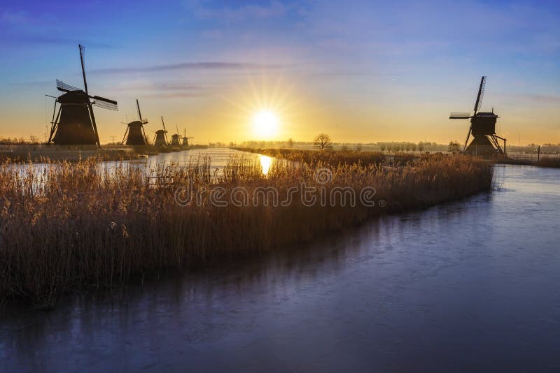 Sunrise of a beautiful Dutch frozen UNESCO windmills alignment at Kinderdijk in Netherlands. Sunrise of a beautiful Dutch frozen UNESCO windmills alignment at Kinderdijk in Netherlands