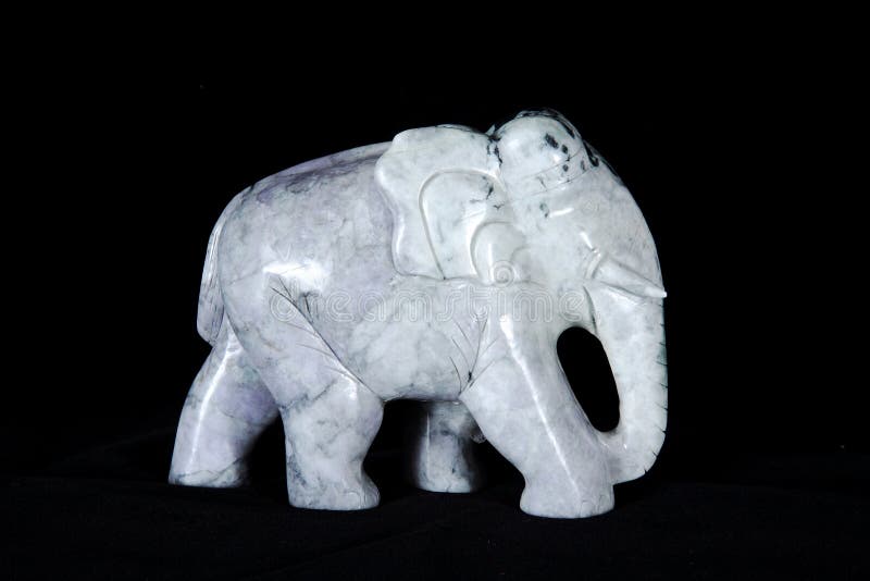 在黑背景隔绝的大象玉雕塑
