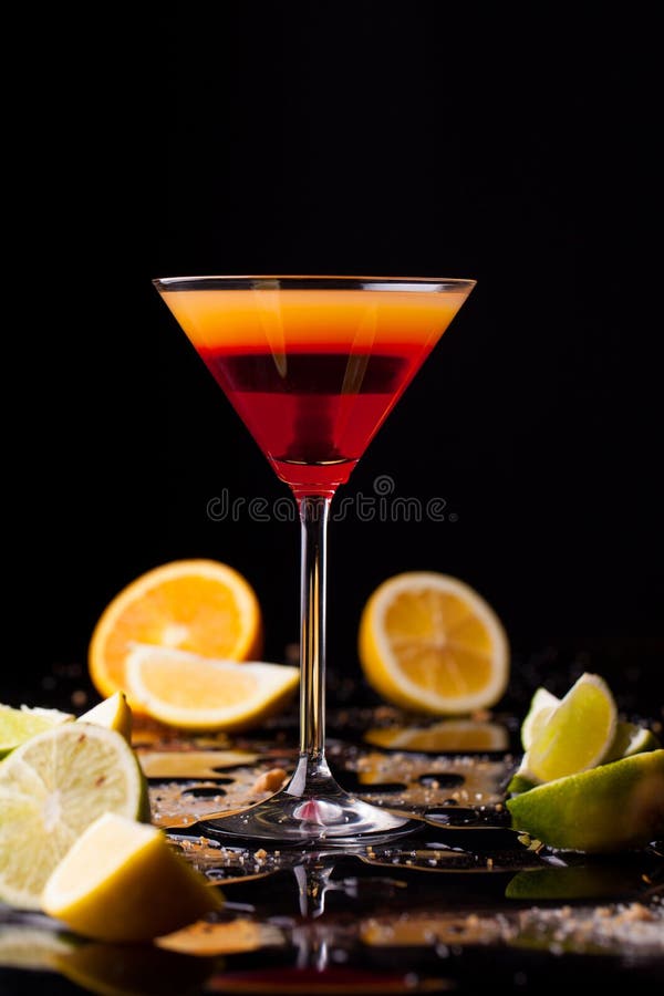 Cocktail drink on black background, citrus fruit on the table. Space in background for copy, text, your words. Cocktail drink on black background, citrus fruit on the table. Space in background for copy, text, your words.