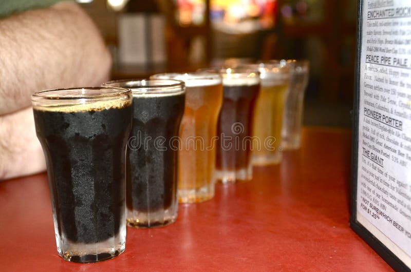 A tasting flight of cold beers, with everything from light ales to dark porters, at a small brewery. A tasting flight of cold beers, with everything from light ales to dark porters, at a small brewery