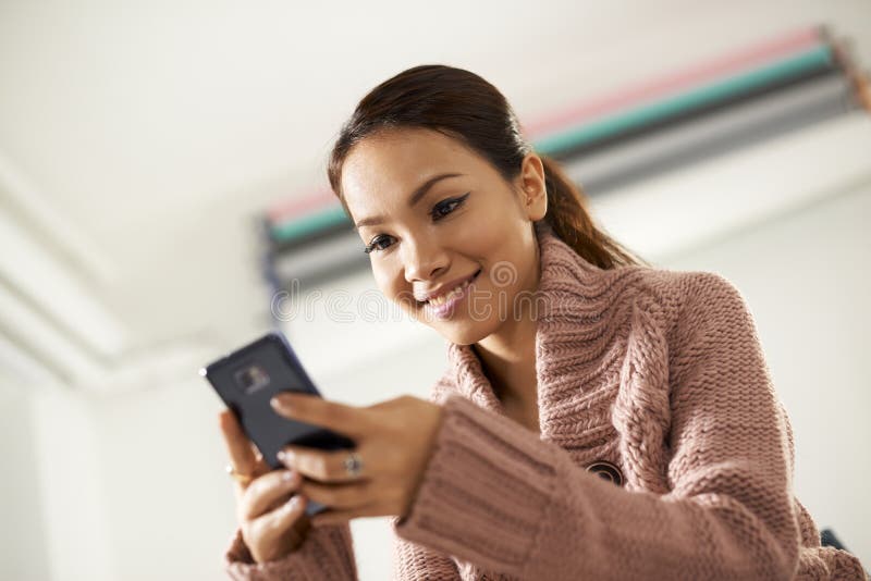 在smarthphone的亚洲女孩读书sms