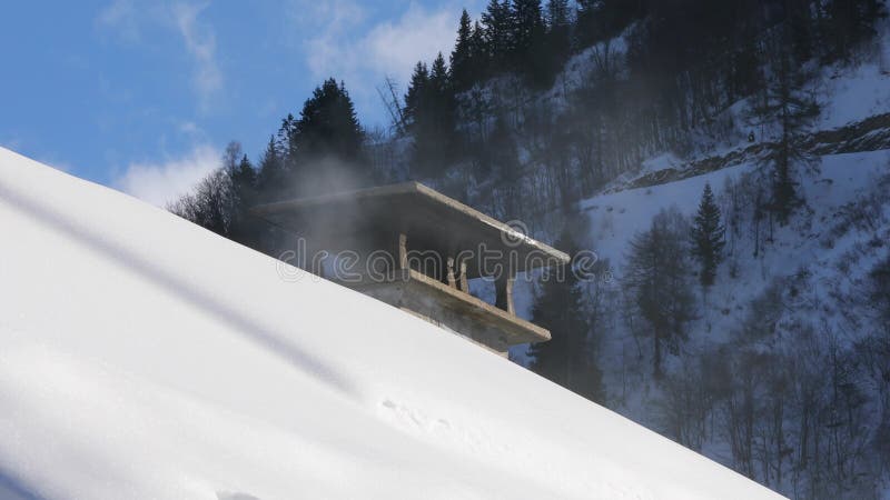 在一个多雪的屋顶的抽烟的烟囱