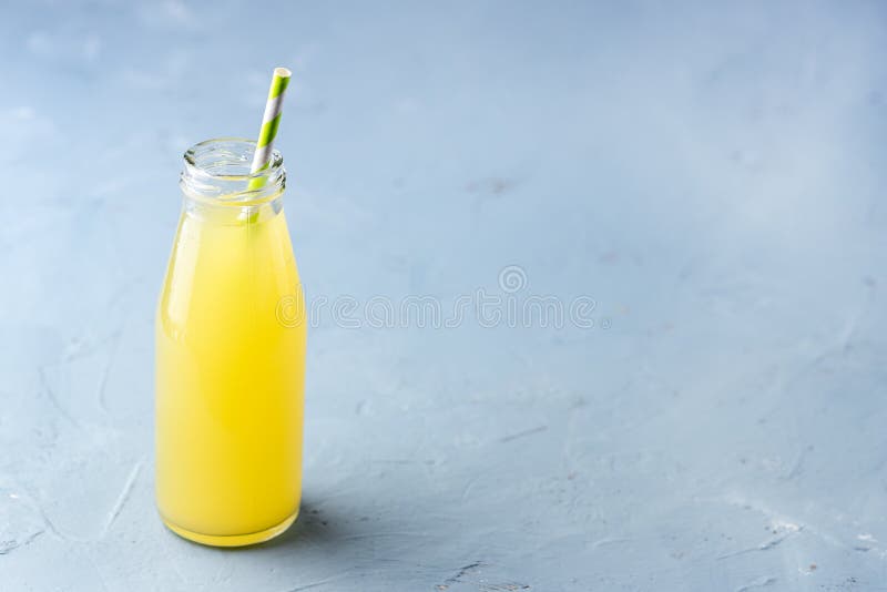 Lemonade on a Blue Background Summer Traditional Italian Homemade Drink Drink of Yellow Color Picture of a Drink in a Bottle Summer Cold Drink Copy Space. Lemonade on a Blue Background Summer Traditional Italian Homemade Drink Drink of Yellow Color Picture of a Drink in a Bottle Summer Cold Drink Copy Space.