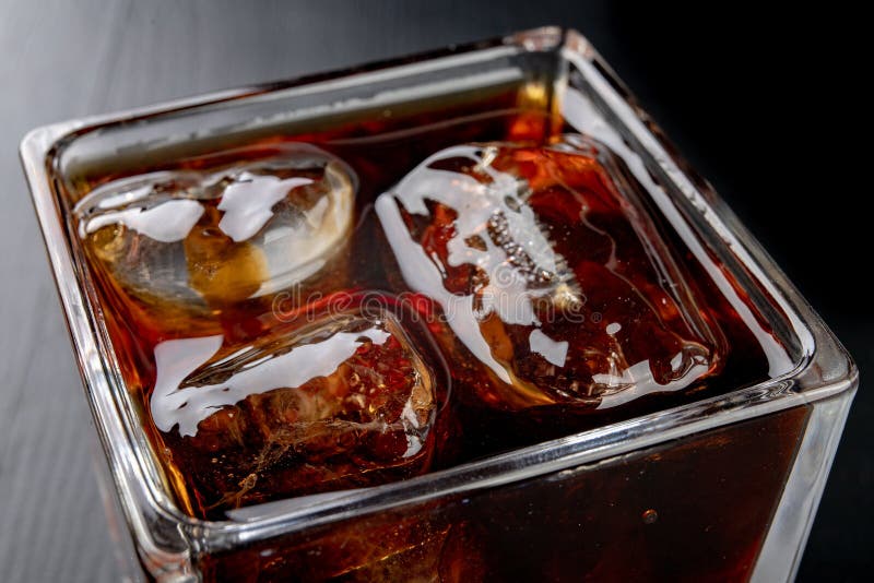 Cold drink in a glass on a wooden table. A chilled drink ready to be eaten. Black background. Cold drink in a glass on a wooden table. A chilled drink ready to be eaten. Black background