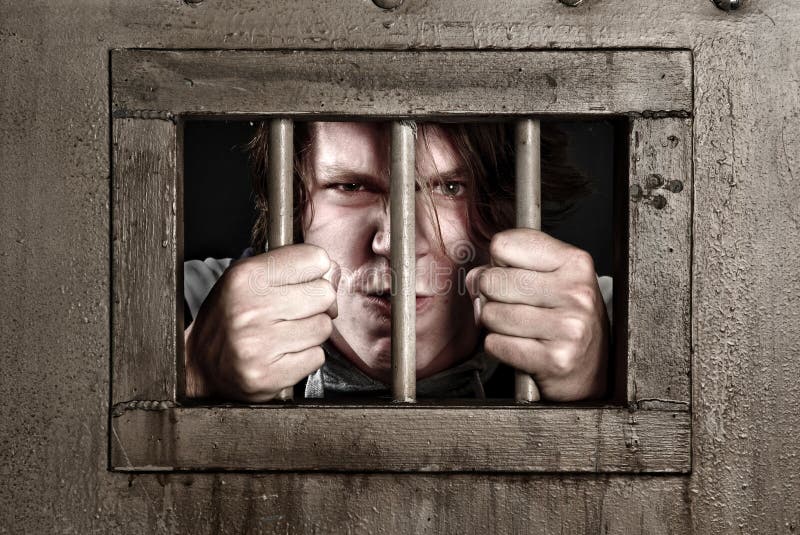 Man in prison holding the bars of his cell door. Man in prison holding the bars of his cell door.