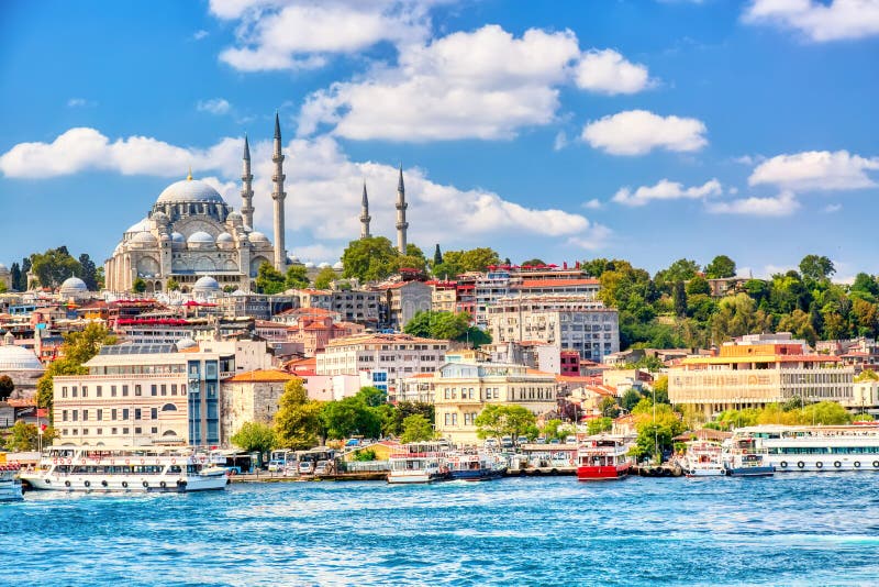 在伊斯坦布尔和看法金黄垫铁海湾的旅游观光的船在Suleymaniye清真寺有Sultanahmet区的反对蓝色 图库摄影 在伊斯坦布尔和看法金黄垫铁海湾的旅游观光的船在Suleymaniye清真寺有Sultanahmet区的反对蓝色 图库摄影