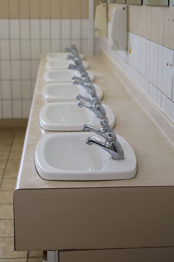 Sinks in a row in public toilet in England. Sinks in a row in public toilet in England