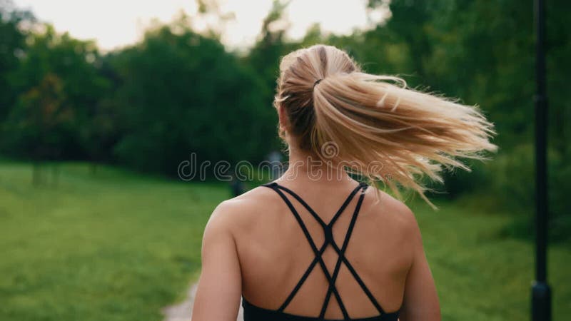 在公园里穿着运动服跑步的女运动员的后视. 在户外运动的运动女子 股票视频