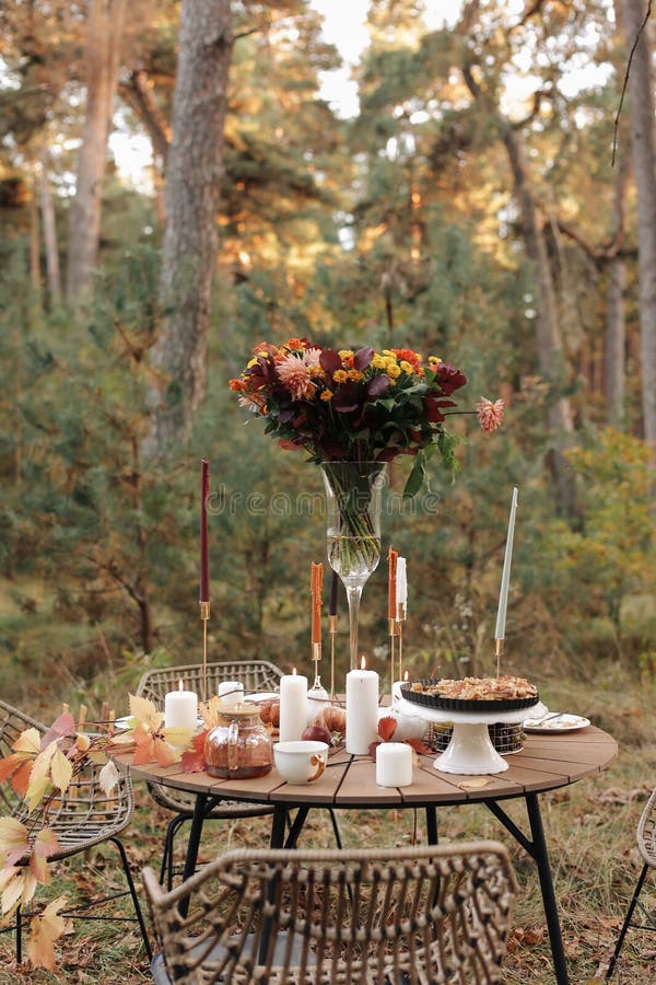 在公园里舒适的秋日野餐. 彩色白板餐具玻璃花瓶桌位特写