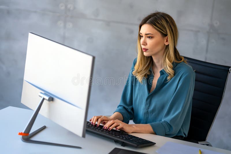 在办公室从事计算机工作的职场成功的年轻职业女性投资经理 库存图片