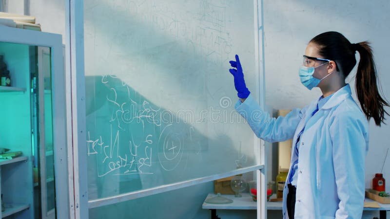 在化学实验室里，有魅力的年轻科学家女性非常善于分析化学配方的透明板 影视素材