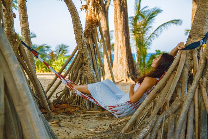 在吊床的画象美好的年轻亚洲妇女幸福微笑休闲在海滩海和海洋附近摇摆有天空蔚蓝白色云彩的 免版税库存图片 在吊床的画象美好的年轻亚洲妇女幸福微笑休闲在海滩海和海洋附近摇摆有天空蔚蓝白色云彩的 免版税库存图片