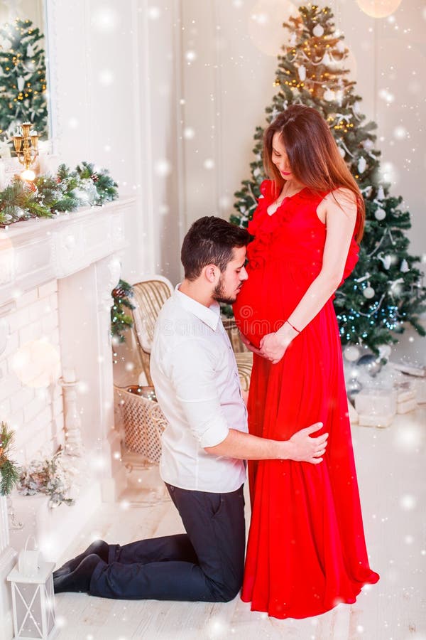 在圣诞节的愉快的家庭夫妇在壁炉 愉快夫妇亲吻和拥抱 Xmas树和当前礼物装饰的客厅 图库摄影 在圣诞节的愉快的家庭夫妇在壁炉 愉快夫妇亲吻和拥抱 Xmas树和当前礼物装饰的客厅 图库摄影