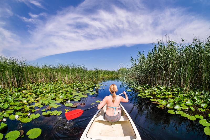 Woman sailing in Danube Delta with a boat canoe. Woman sailing in Danube Delta with a boat canoe