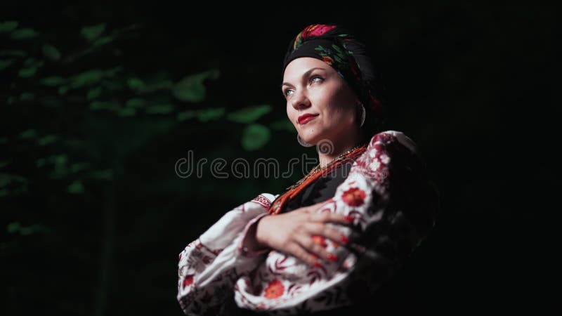 在夜林背景中戴着传统乌克兰手帕的项链和服装的美女. 全国女士 股票视频