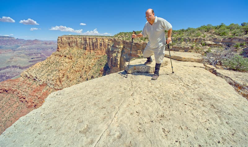 A hiker on the edge of a cliff between Moran Point and Zuni Point at Grand Canyon Arizona. A hiker on the edge of a cliff between Moran Point and Zuni Point at Grand Canyon Arizona