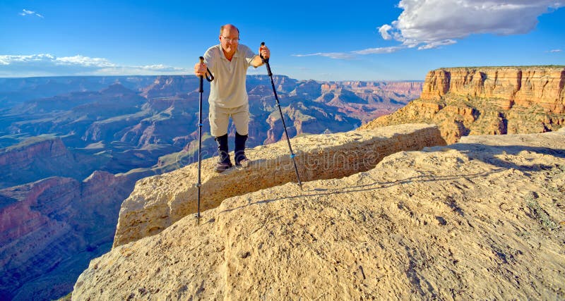 A hiker on the edge of a cliff between Moran Point and Zuni Point at Grand Canyon Arizona. A hiker on the edge of a cliff between Moran Point and Zuni Point at Grand Canyon Arizona