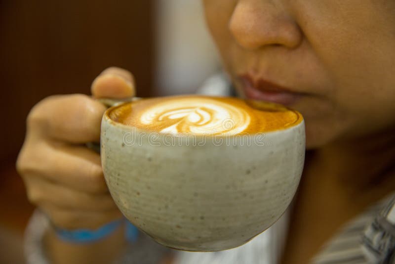 BANGKOK, THAILAND - August 18, 2018: Closeup of women holding a mug of coffee, enjoyment and relaxation coffee time. BANGKOK, THAILAND - August 18, 2018: Closeup of women holding a mug of coffee, enjoyment and relaxation coffee time