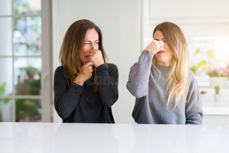 在家一起闻到东西腐败和恶心的不可容忍的气味储备的母亲和女儿美丽的家庭 免版税库存图片