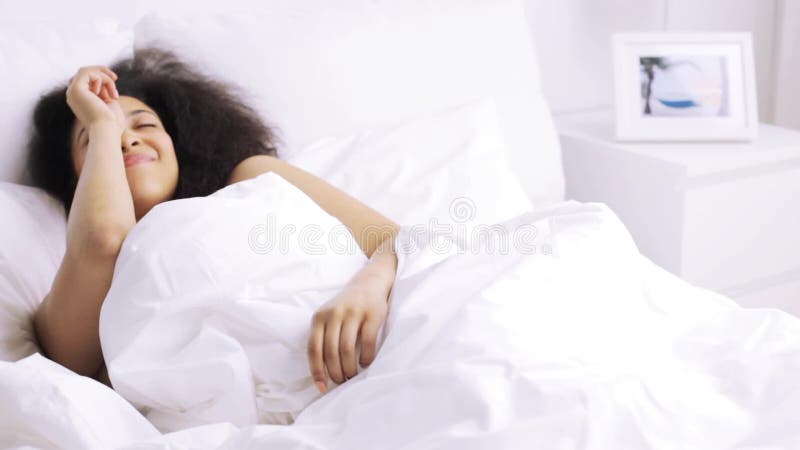 在家睡觉在床卧室的非洲妇女