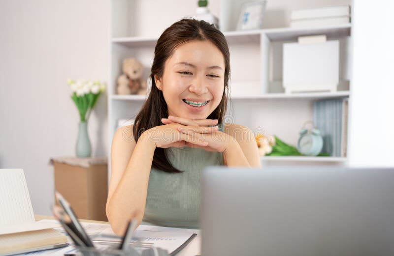 在家课堂上观看教师现场表演或视频通话的亚洲年轻女学生 免版税库存照片