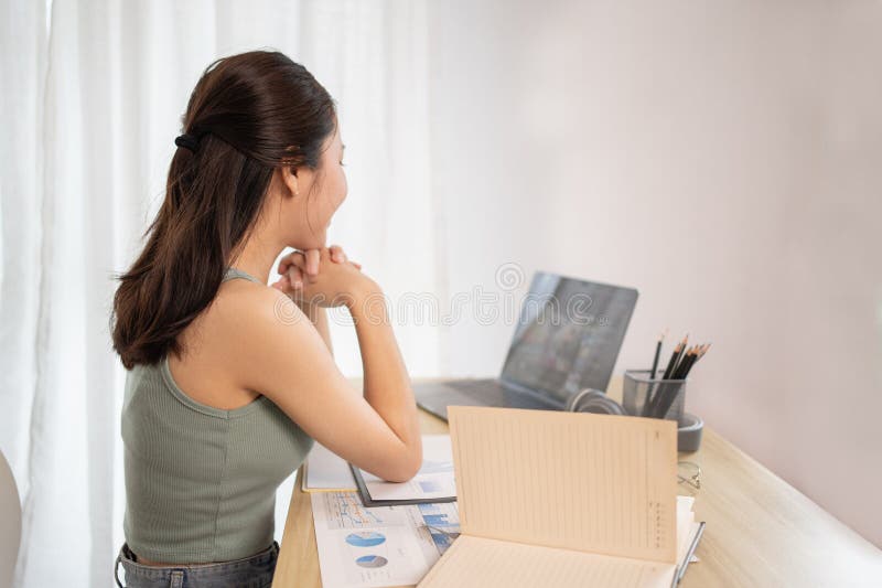 在家课堂上观看教师现场表演或视频通话的亚洲年轻女学生 免版税图库摄影