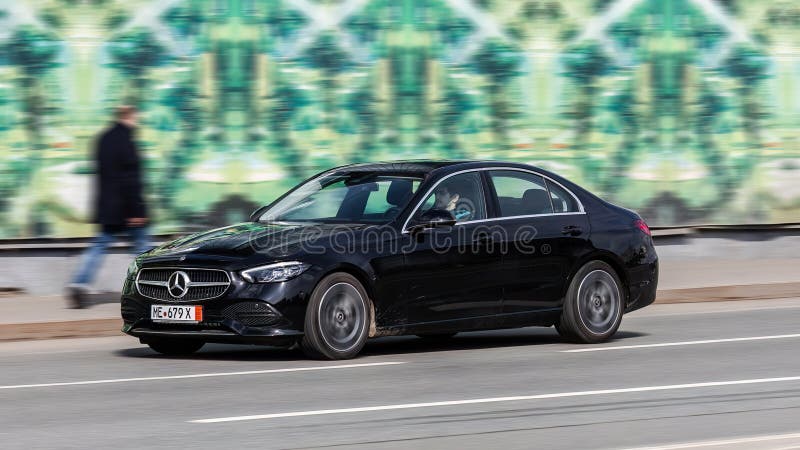 Moscow, Russia - March 2023: Mercedes C-Class W206 at the city road in motion. Black car driving along the street in city, front side view. Accelerating with low-emission. Moscow, Russia - March 2023: Mercedes C-Class W206 at the city road in motion. Black car driving along the street in city, front side view. Accelerating with low-emission