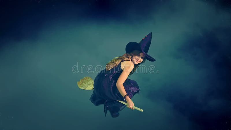 在打破云彩大量的笤帚的美好的年轻巫婆飞行
