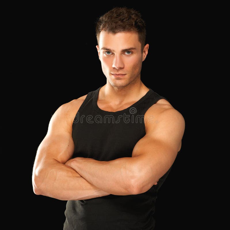 Happy fit male with arms crossed posing over black background. Happy fit male with arms crossed posing over black background