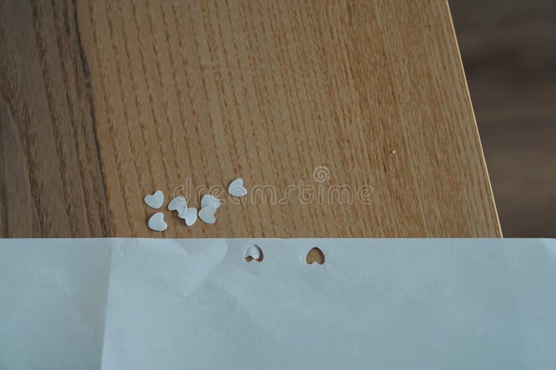 在木桌上用纸做的小小白心，在情人节这天，爱着象征手工制作的 免版税库存照片