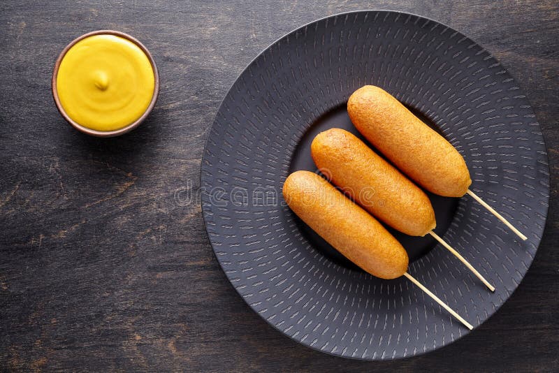 在棍子的玉米面热狗传统美国corndog街道速食被油炸的热狗肉香肠快餐款待 库存照片