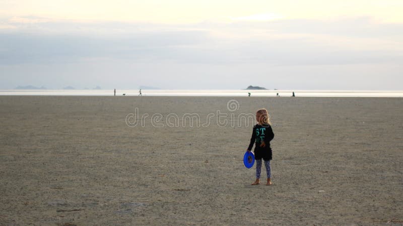 在沙滩上扔运动器材的小女孩