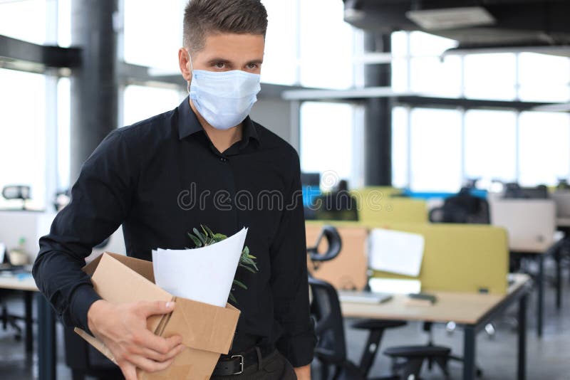 Dismissal employee in an epidemic coronavirus covid-19. Dismissed worker going from the office with his office supplies. Dismissal employee in an epidemic coronavirus covid-19. Dismissed worker going from the office with his office supplies.