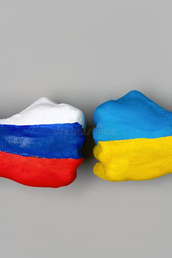 Flags of Ukraine and Russia Flag on hands punch to each other on light gray world map background, Ukraine vs Russia in world war crisis concept. Vertical photo. Flags of Ukraine and Russia Flag on hands punch to each other on light gray world map background, Ukraine vs Russia in world war crisis concept. Vertical photo.