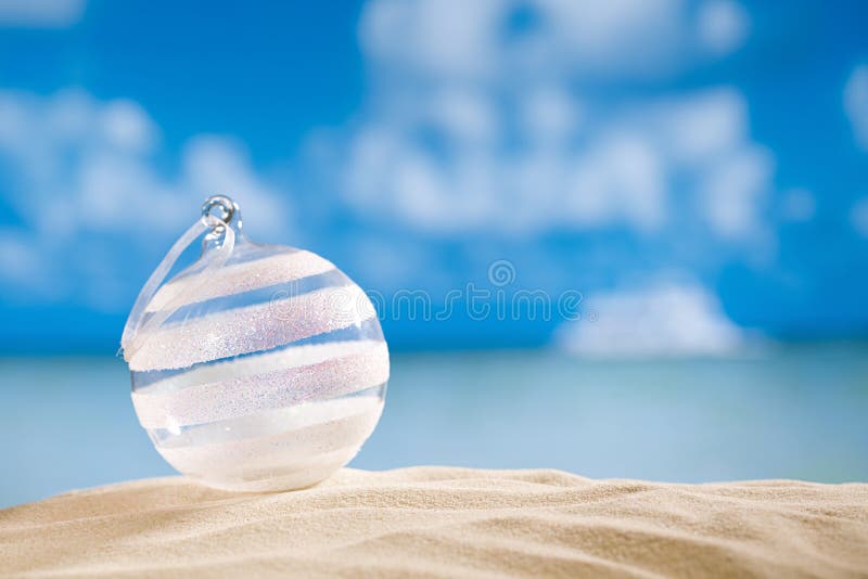 在海滩的闪烁圣诞节玻璃球与海景