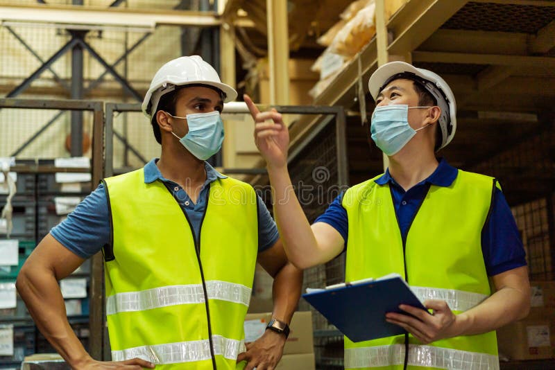 在物流行业工作时戴防护面罩的年轻仓库工人. 亚洲