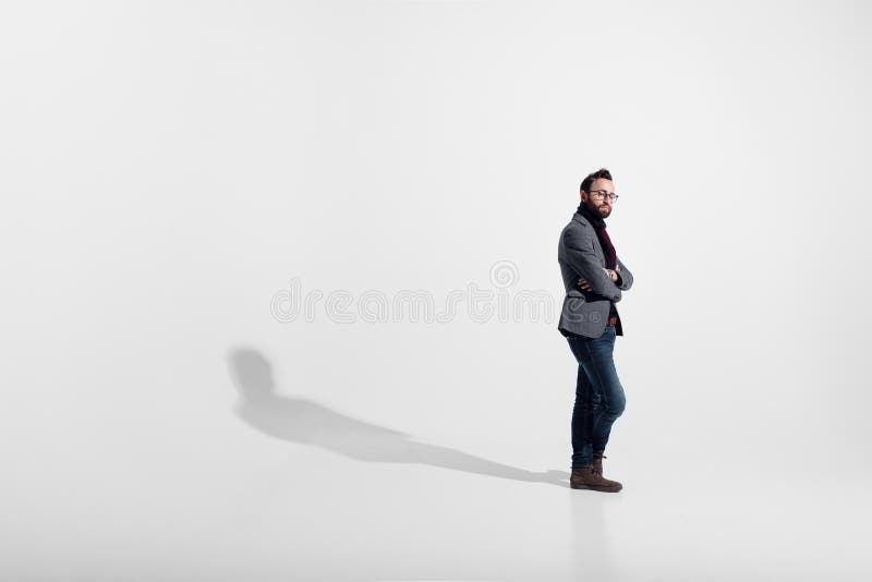 在白色演播室背景隔绝的时髦的人,镜片,站立的充分的高度,当横渡的胳膊,看照相机 库存照片 在白色演播室背景隔绝的时髦的人,镜片,站立的充分的高度,当横渡的胳膊,看照相机 库存照片
