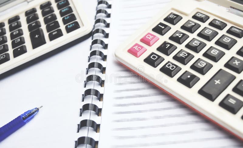 2 Calculator on Notebook with pen with blur text. 2 Calculator on Notebook with pen with blur text