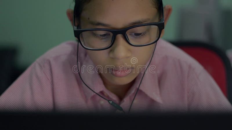 在网上学习，总结经验教训，从笔记本电脑的肖像可爱的亚洲少女戴耳机. 影视素材